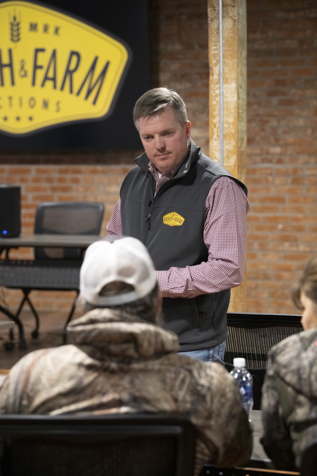 An auction ringman helps lead the effort of identifying bids in the bidding pool.
